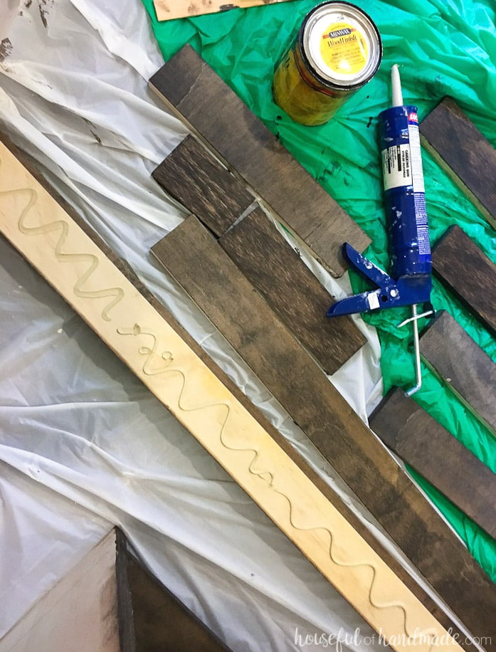 Applying liquid nails to the rear of one closet shelf support. 