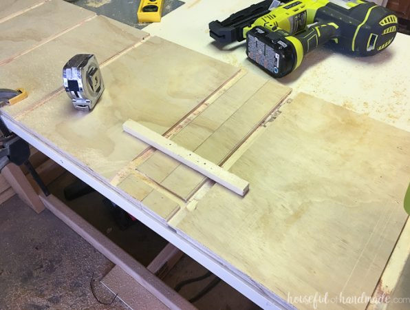 A scrap wood guide nailed to the board for routing the toe kick groove.