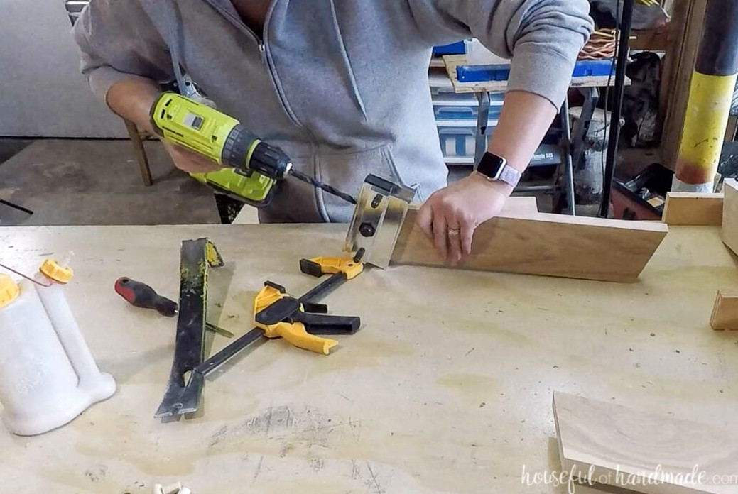 Creating dowel-pin openings in the upper ends of the leg boards with a self-centering doweling jig. 