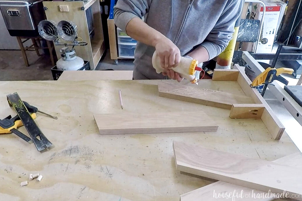 Adding glue to one of the leg pieces in the DIY jig. 