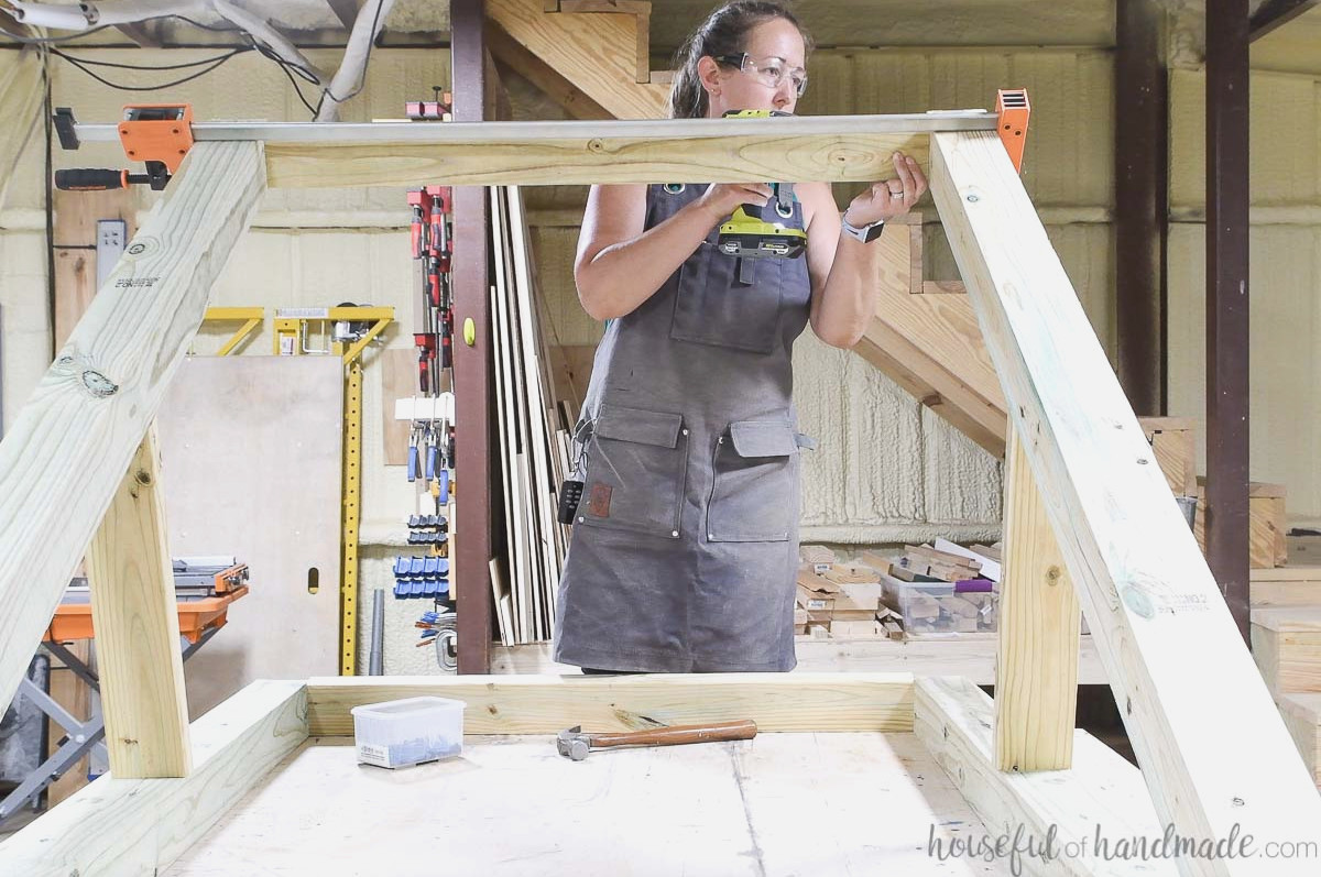 Joining the hanging chair stand legs at the bottom with 2x4 boards.