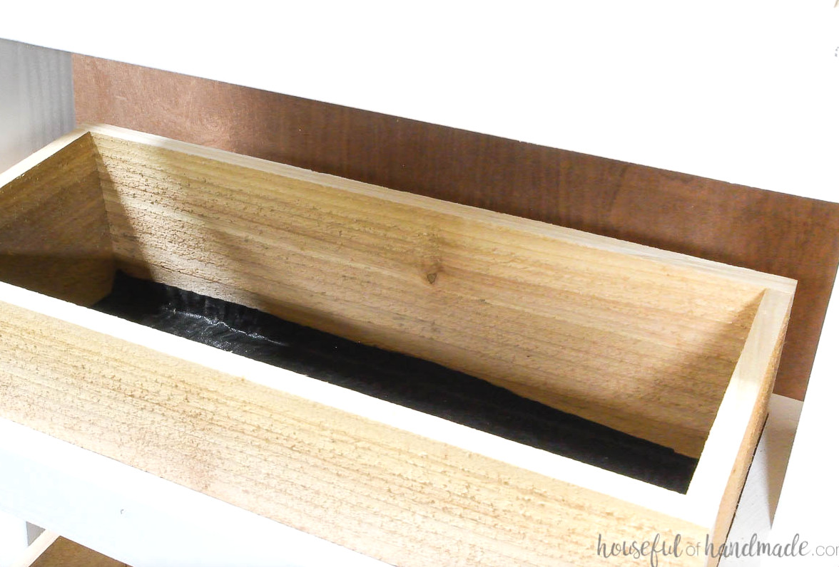 Landscaping fabric trimmed to fit inside the cedar planter box bottom.
