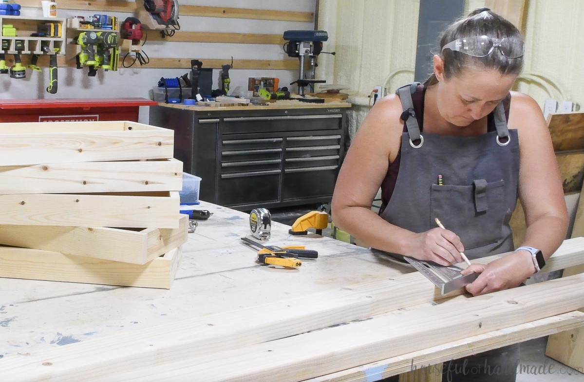Using a speed square to mark planter box locations on the ladder sides.