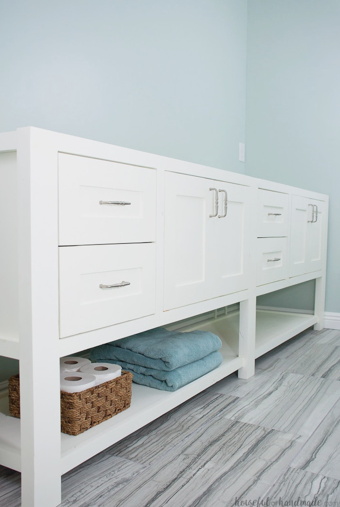 Large double vanity with an open shelf underneath, painted white. 