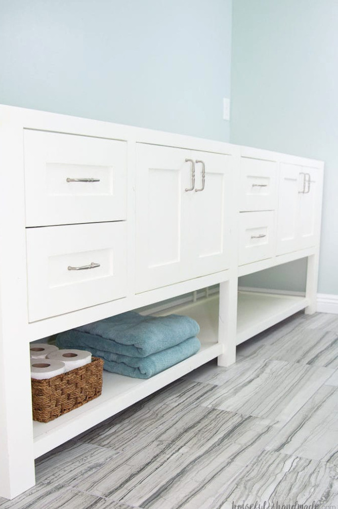 Double vanity featuring two drawer sections and 2 cabinets with a broad open shelf underneath.
