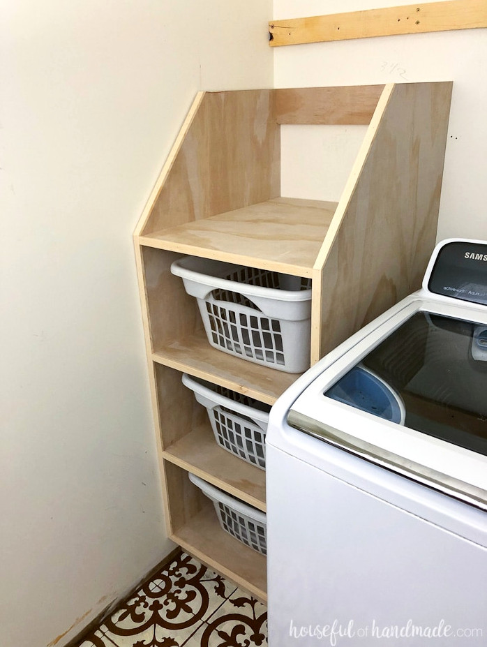 Stackable laundry basket organizer shown on side of washing machine.