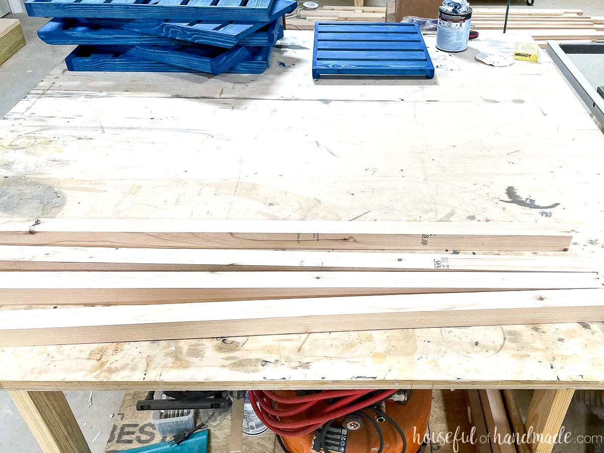The cut 2x2 plant stand boards placed in front of the blue-stained shelves. 