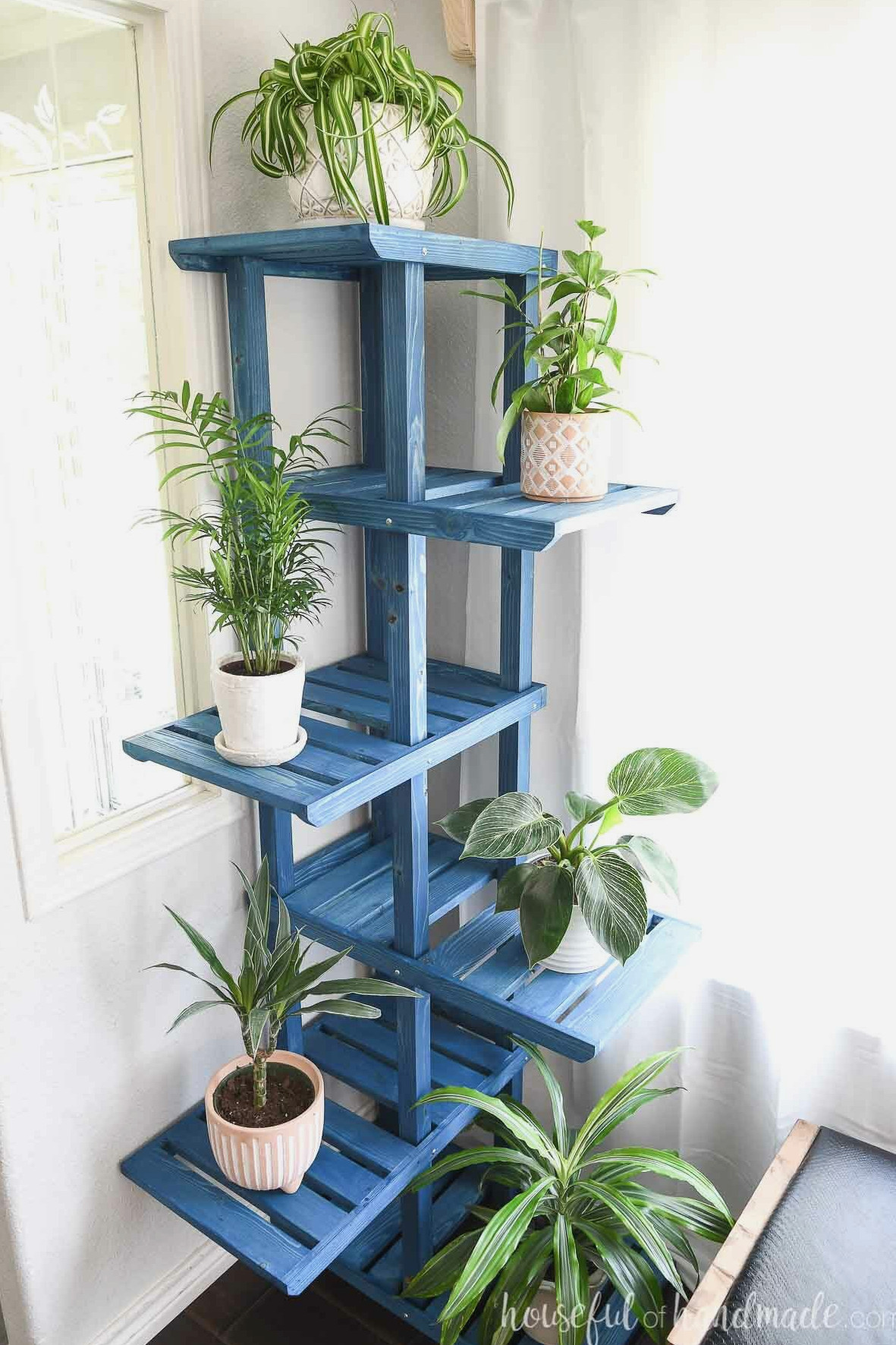 Blue-finished plant stand featuring 6 spacious shelves in a corner. 