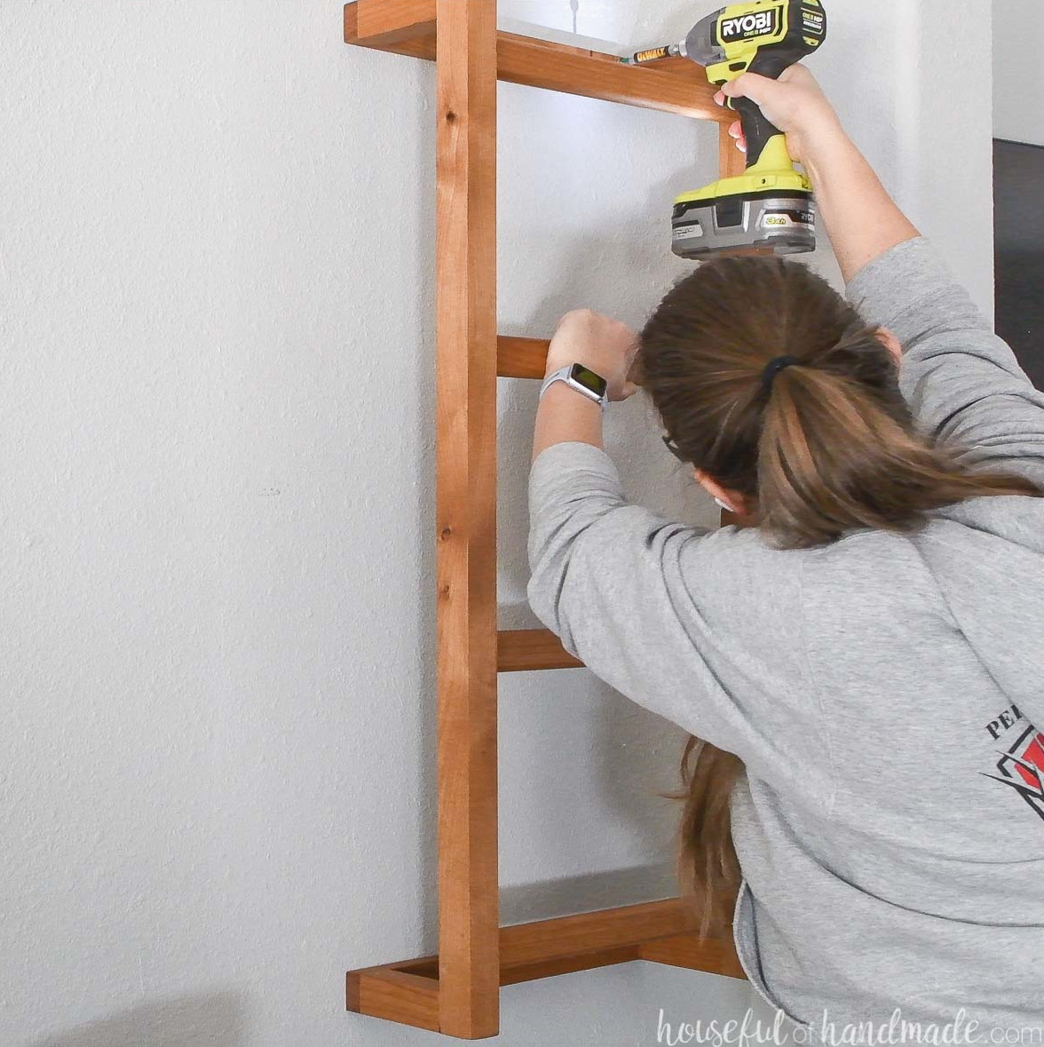 Fastening the wooden wall ladder securely to the wall. 