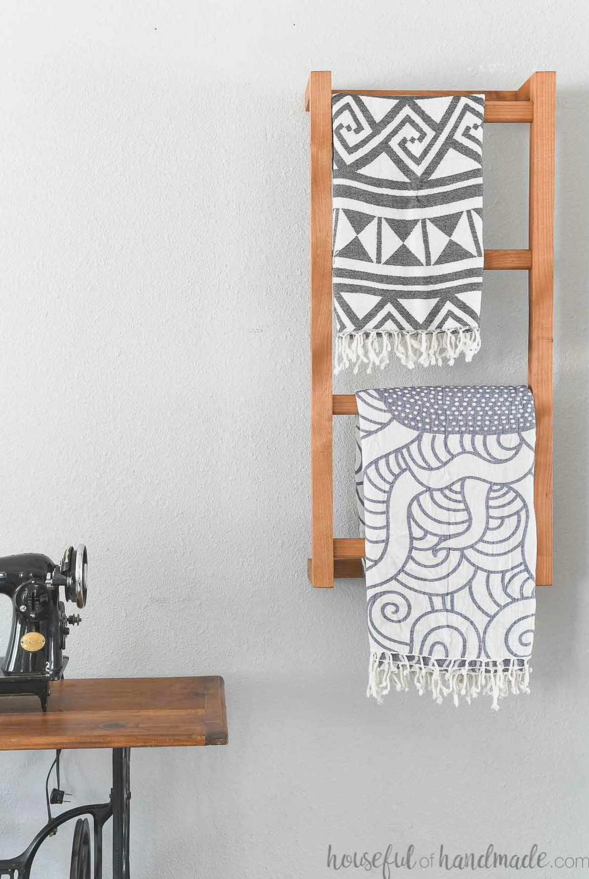 Wooden wall-mounted blanket ladder holding two throw blankets. 