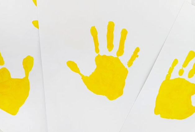 Yellow handprints on paper