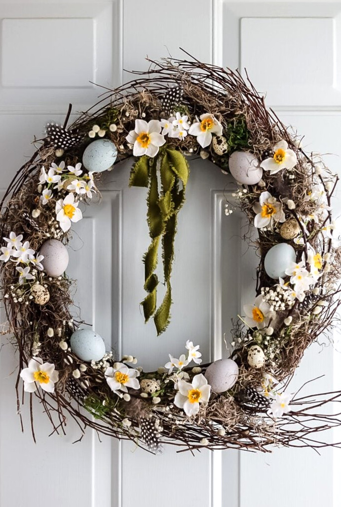 pretty spring wreath with flowers and eggs on front door