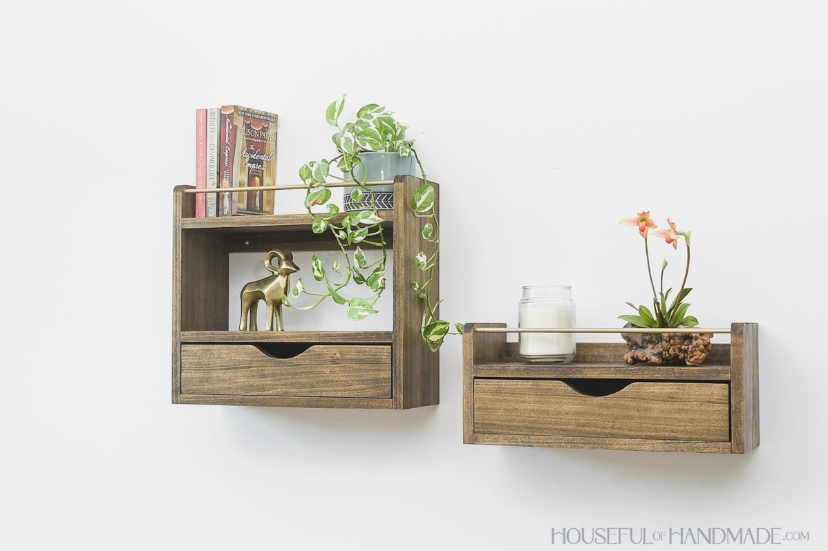 Two floating wall shelves with drawers on the bottom and a railing on top.