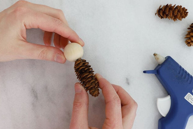 Gluing bead to pine cone