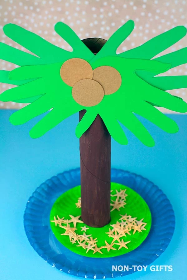 Palm tree craft made with handprints, paper roll and paper plates.