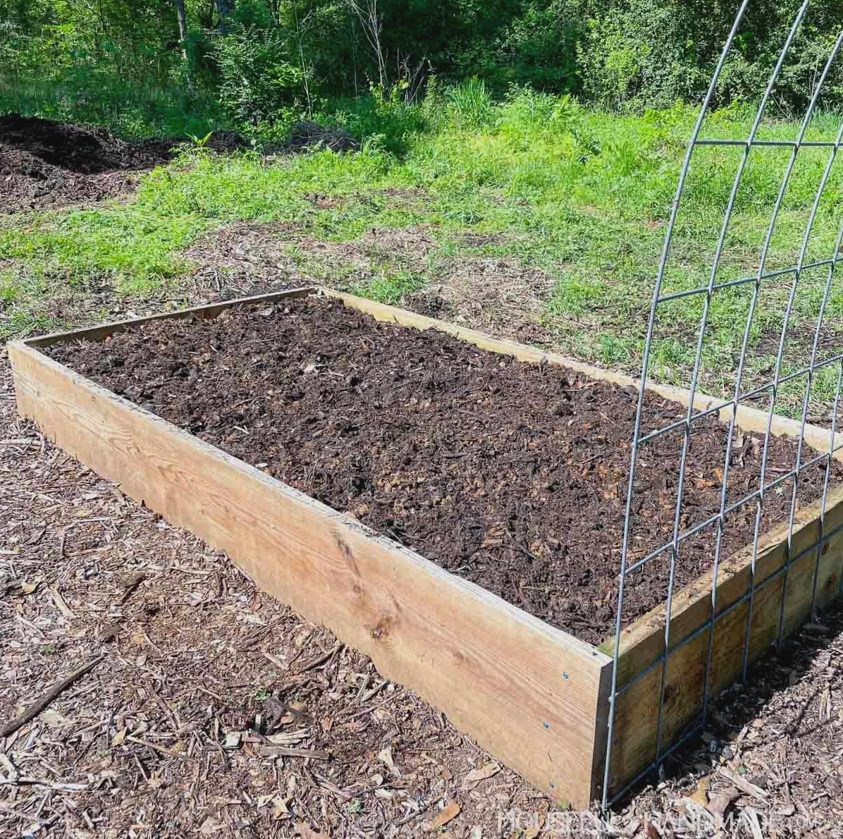 Wood raised garden bed filled with compost.