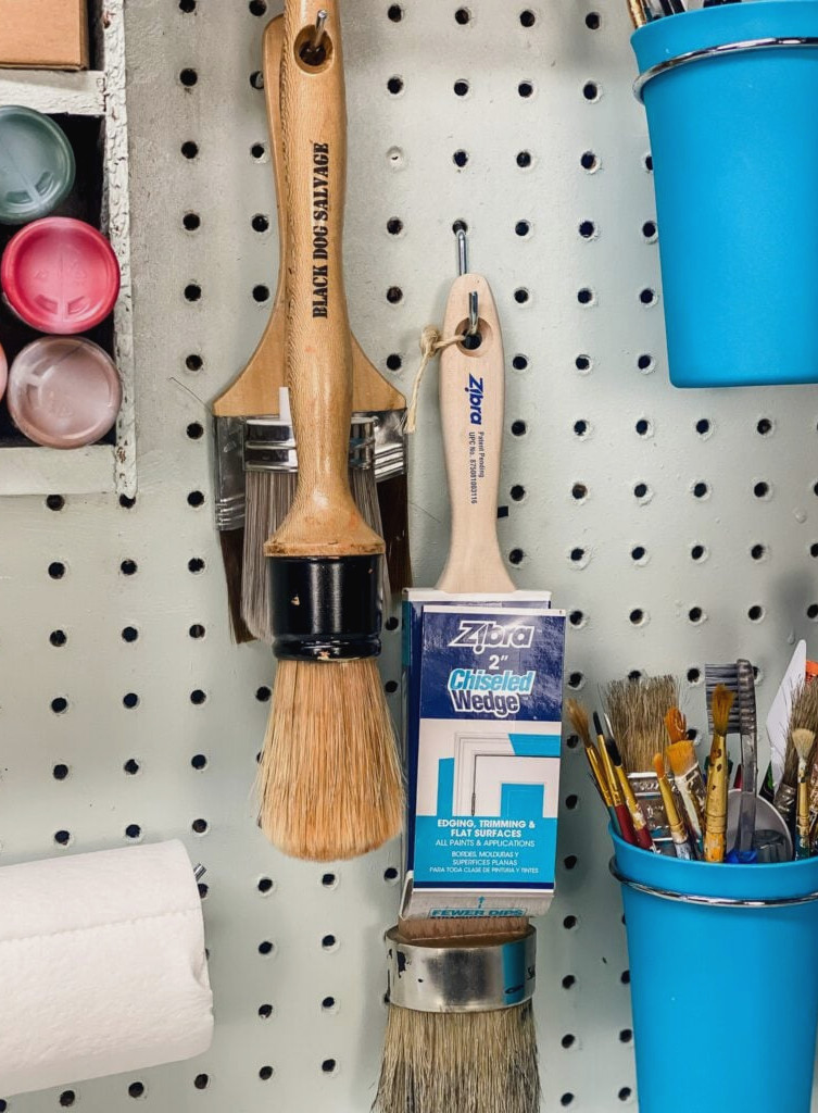 paintbrushes hanging on pegboard