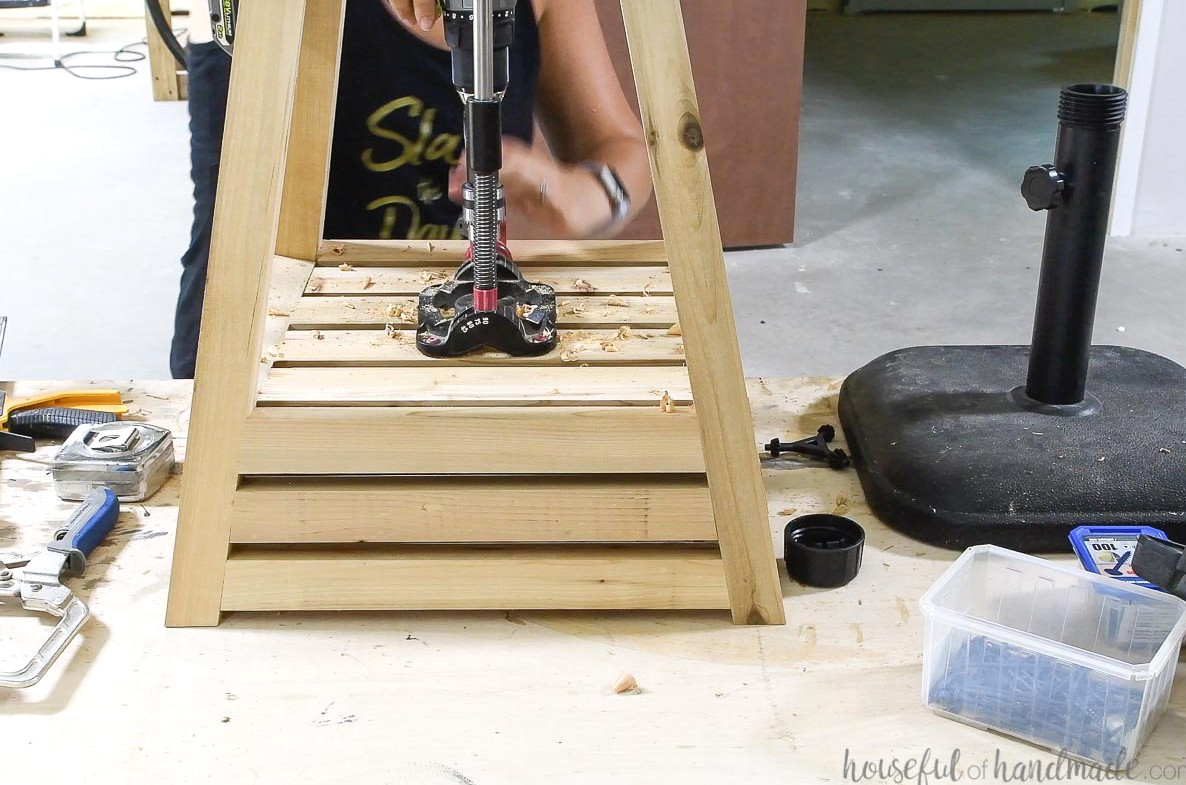 Drilling a hole in the base for the umbrella stand to fit through with a drill guide.