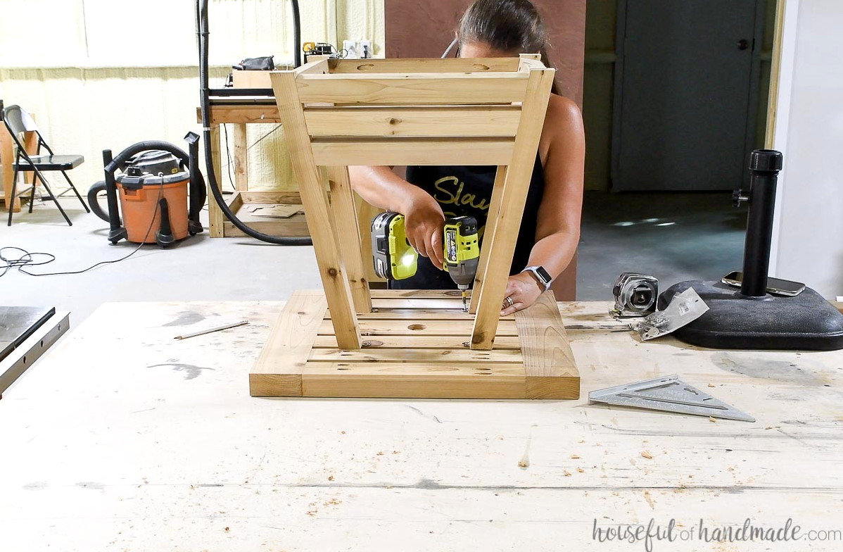 Fastening the table base onto the table top.