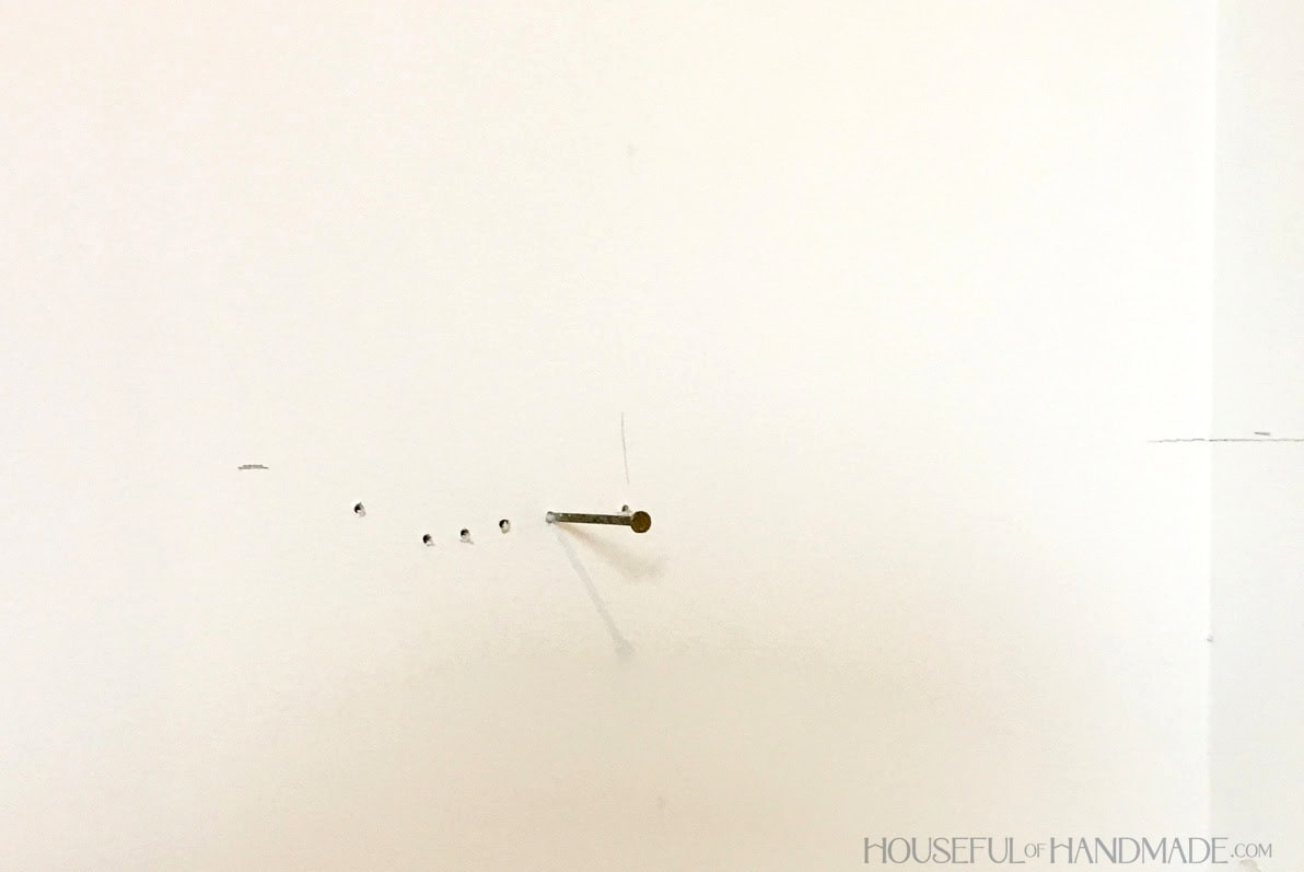 Closet wall showing a nail being used to locate the studs.