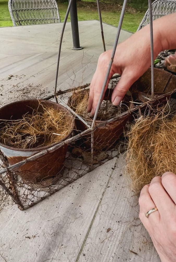 filling a rusty planter with coco liner to house succulents