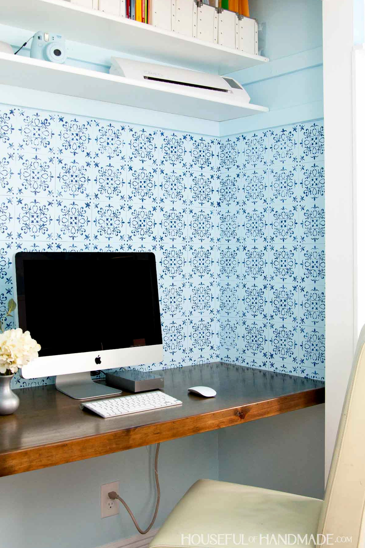 Affordable built-in closet desk with bookcases, a wooden computer desk, a chair, and a computer resting on the desktop.