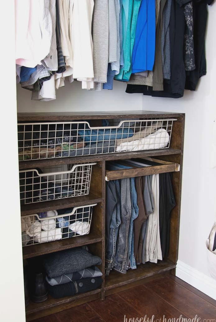 DIY closet storage system featuring baskets and shelves crafted from plywood.