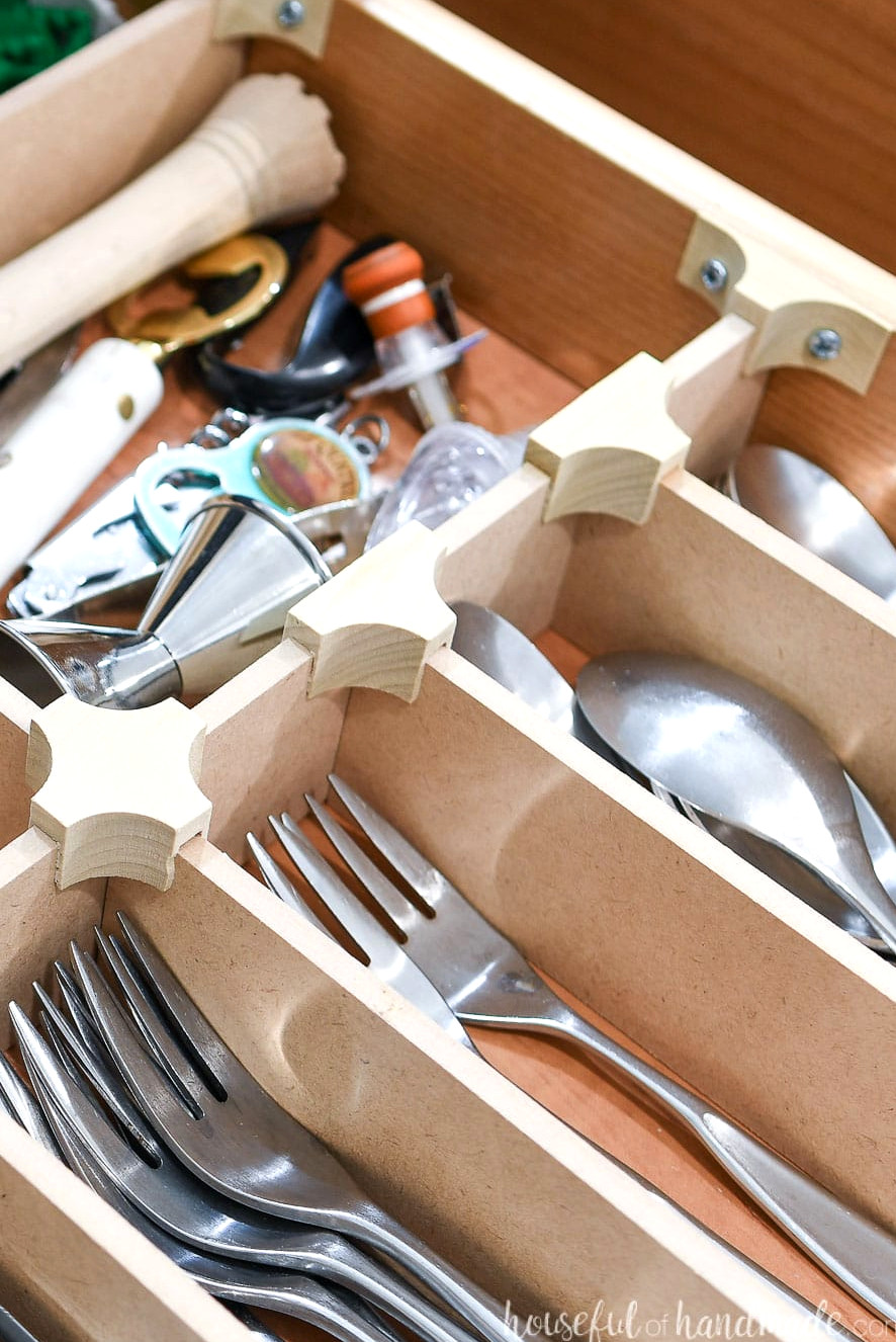 Close view of the T, X, and end cap clips attached to the wooden drawer organizer.