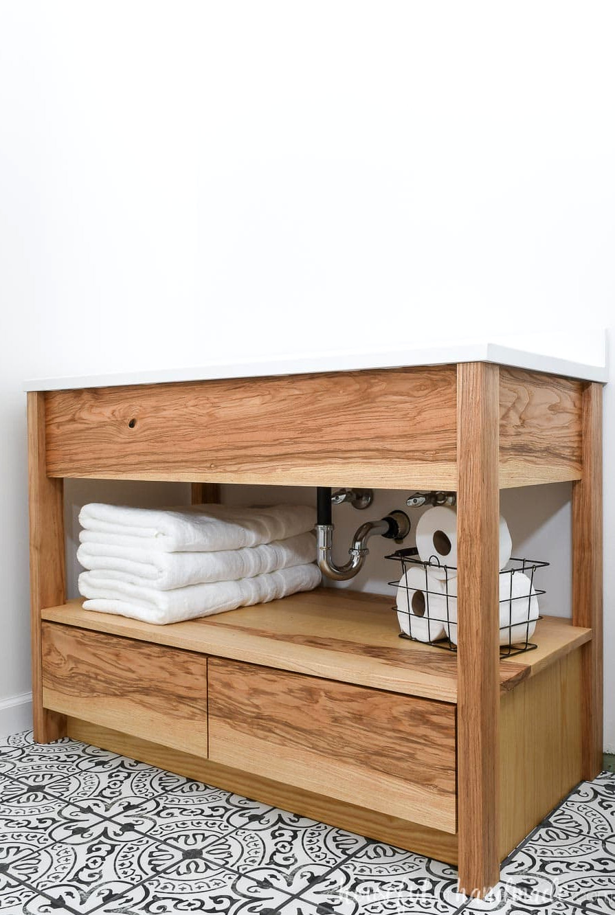 DIY 42" bathroom vanity made from ash wood with an open shelf for towels and bottom drawers.
