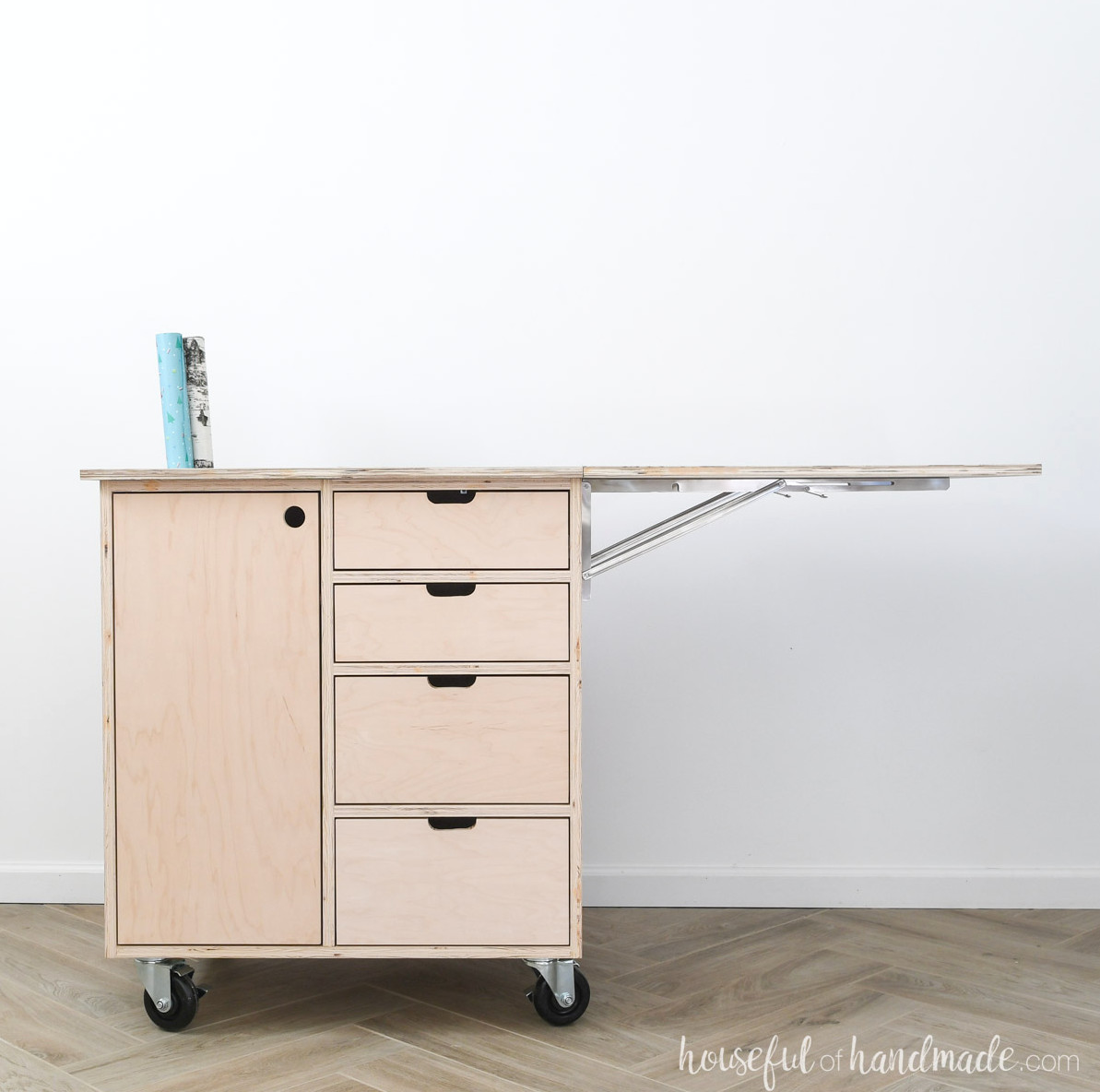 DIY present-wrapping cart featuring four drawers, a cabinet and a leaf on one side.