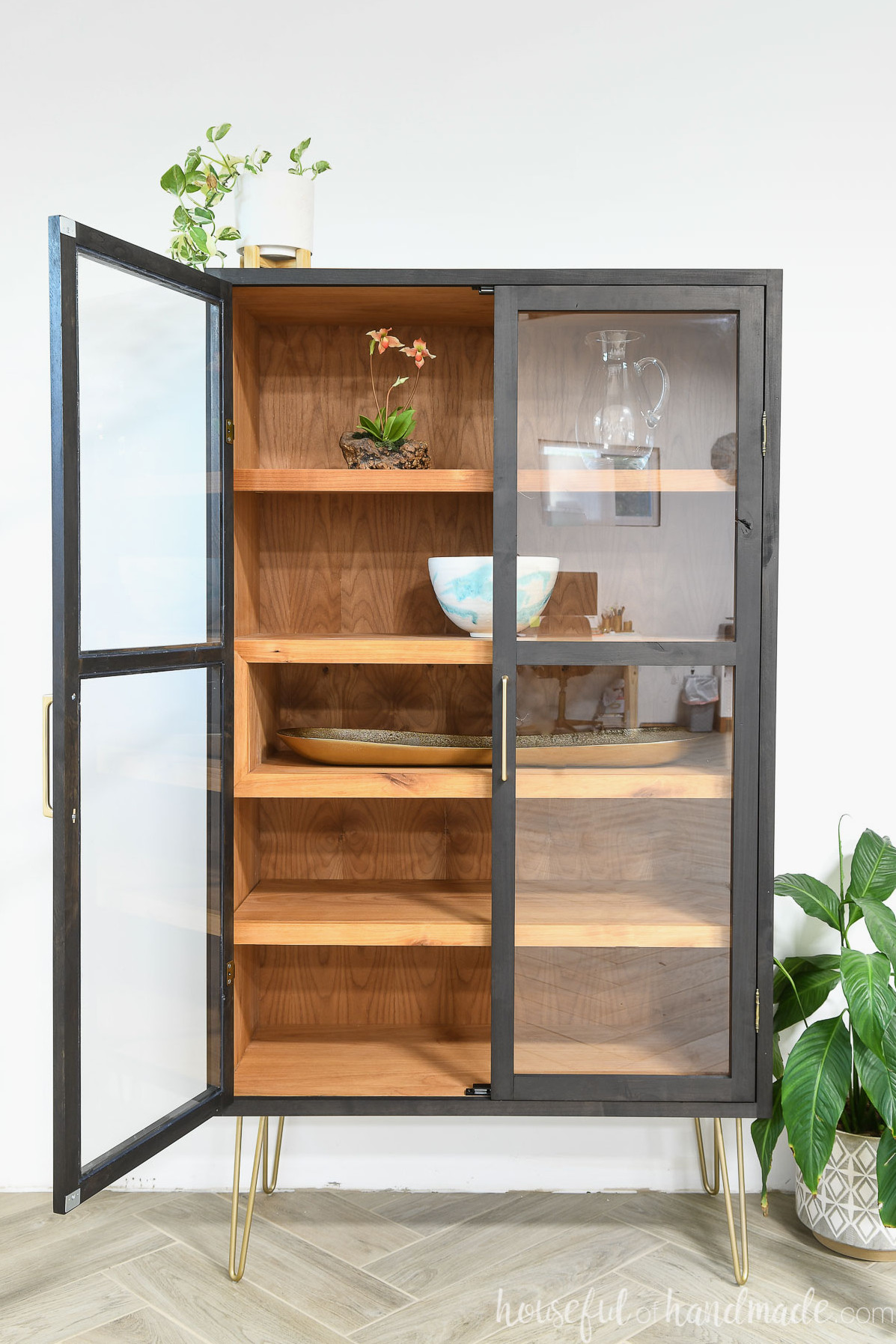 DIY contemporary display cabinet with alder wood on the inside and a black-stained exterior, two framed glass doors, and a display cubby.