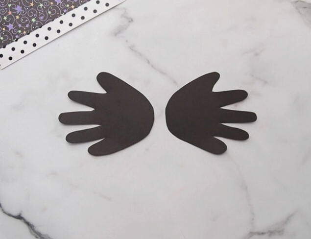Trace and cut handprints from black paper