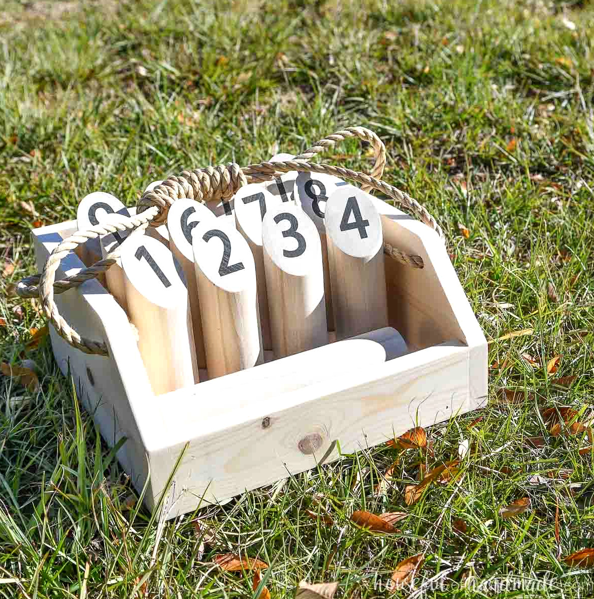 DIY Mölkky game stored in a carrier on the lawn.
