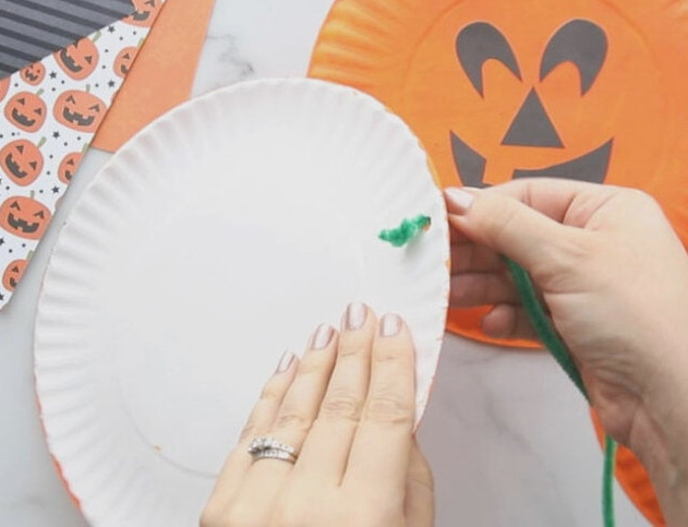 Tie pipe cleaner behind paper plate