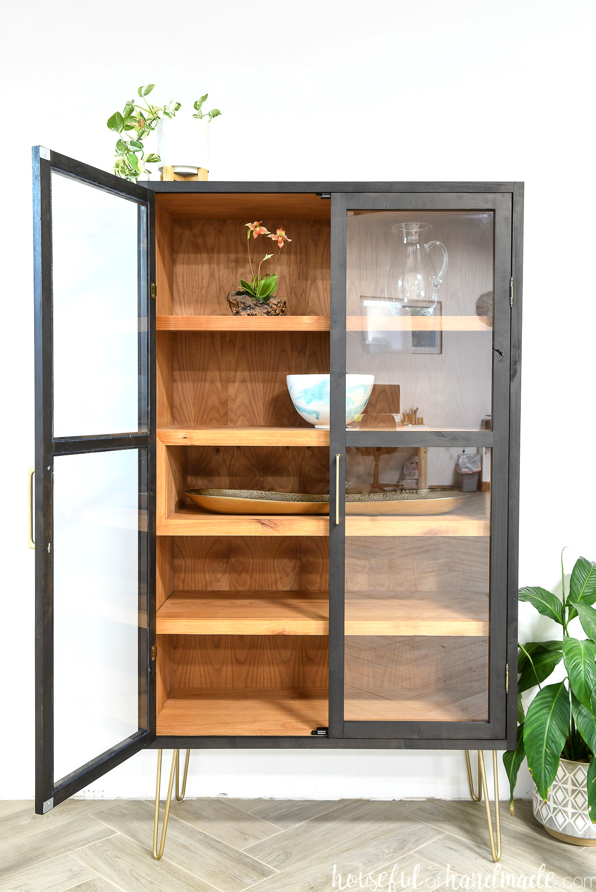 DIY modern display cabinet with alder wood inside and stained black on the outside, two panel glass doors and display cubby.