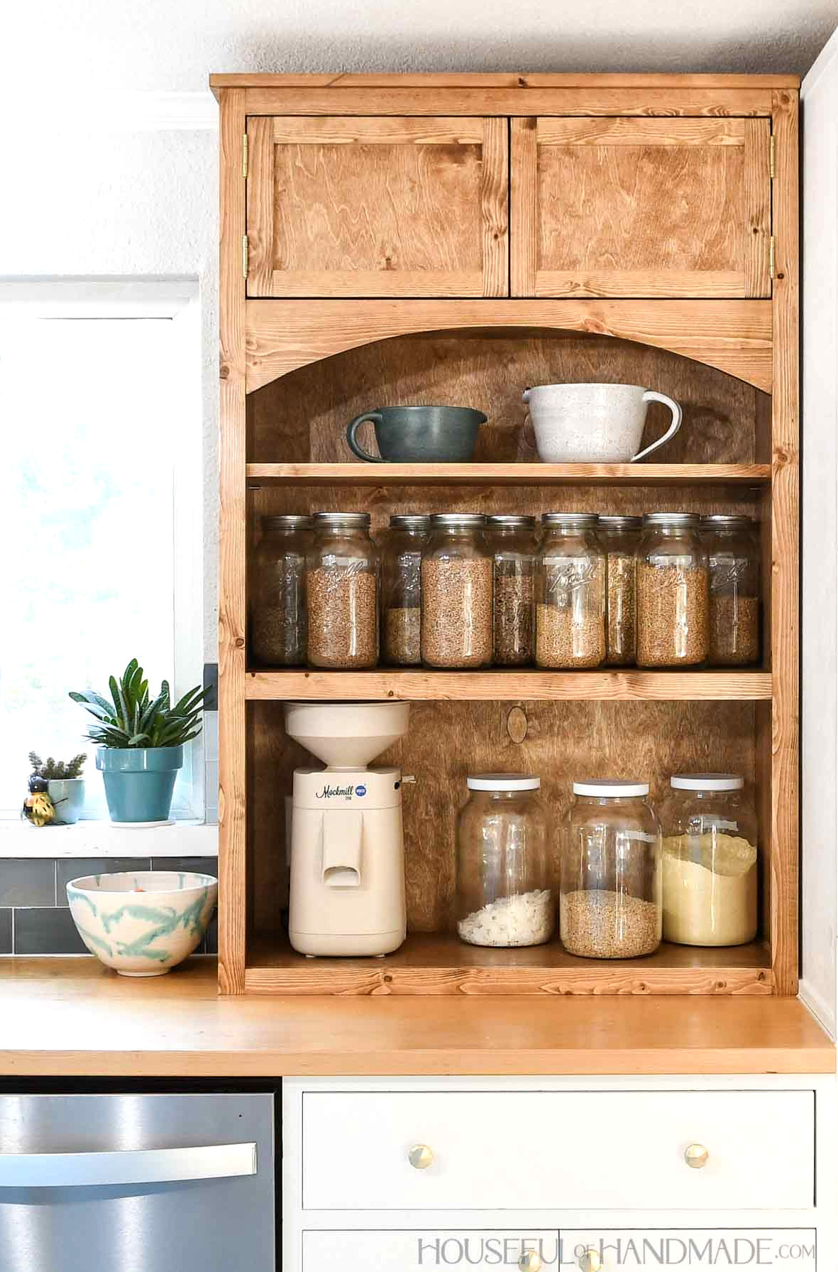 Kitchen hutch with open shelves on bottom and doors on the top sitting on a countertop. 