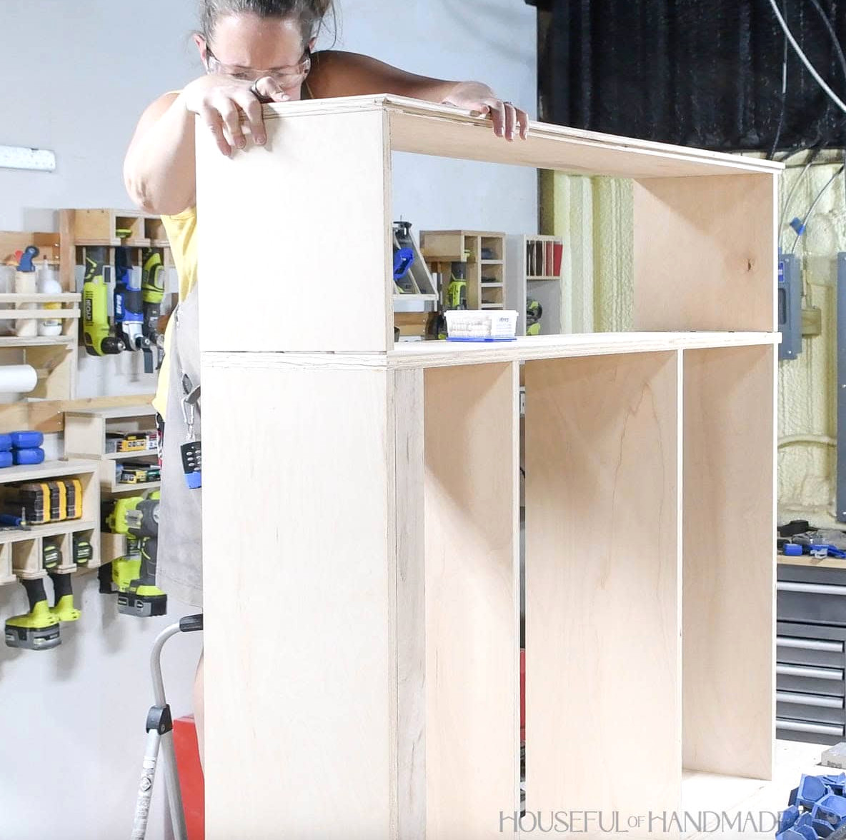 Joining the smaller cabinet section to the side of the first cabinet to create the larger unit. 
