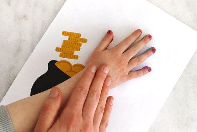 Printing hand onto rainbow cauldron