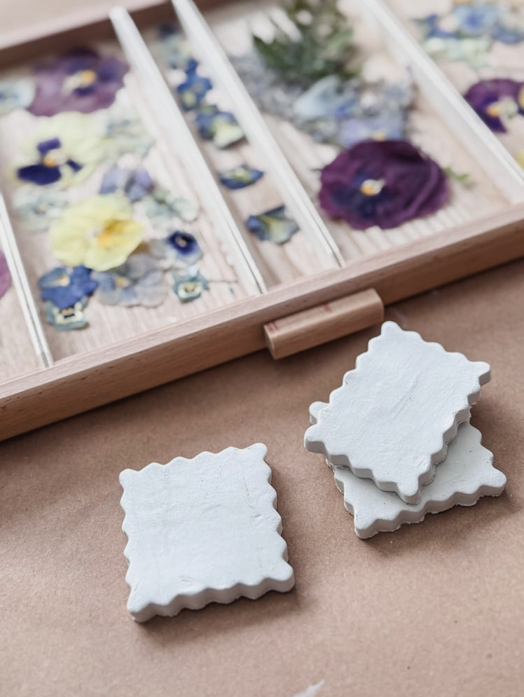 air-dry clay magnet project decorated with pressed flowers in a drawer