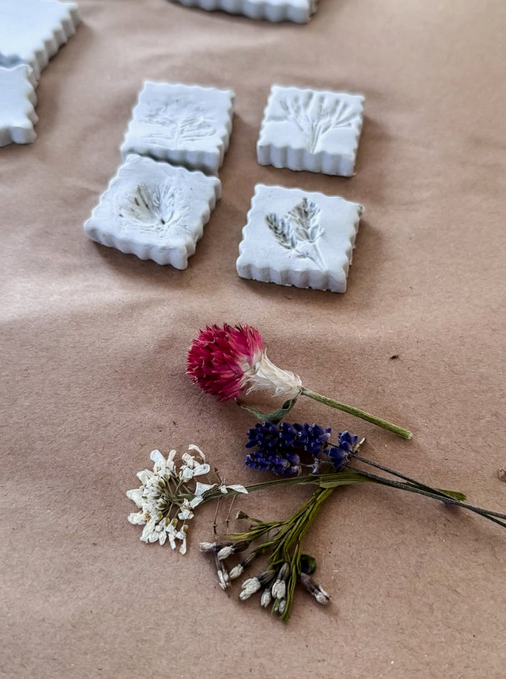 clay shapes with flower imprints and dried flower bundle