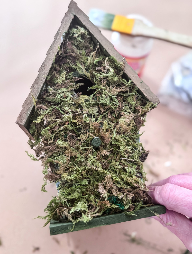 a moss covered birdhouse