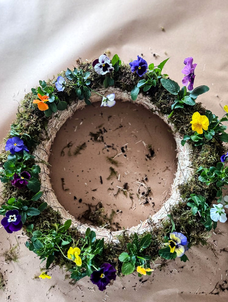 overhead view of a diy pansy wreath on brown paper background
