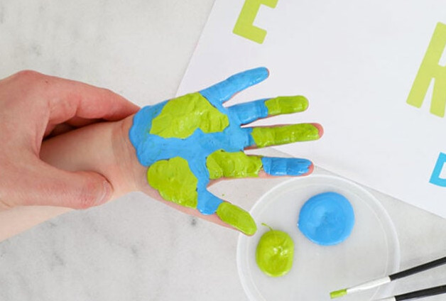 Hand covered with green and blue paint