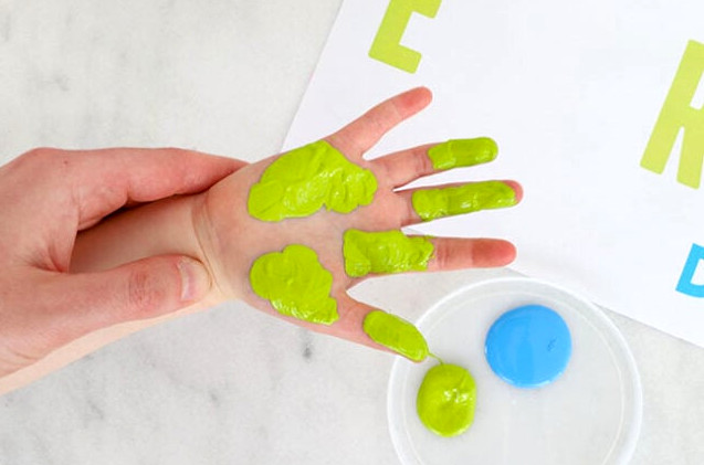 Hand partially covered in green paint