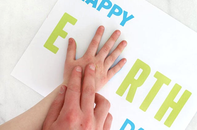 Hand pressing onto Earth Day paper