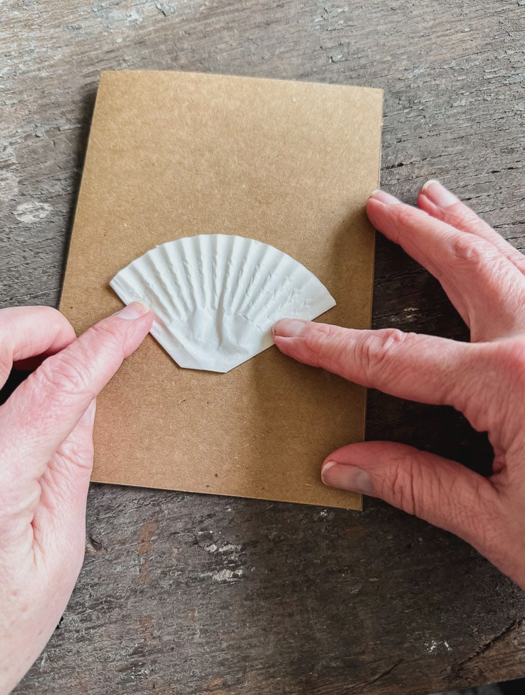 gluing a cupcake liner onto a brown card