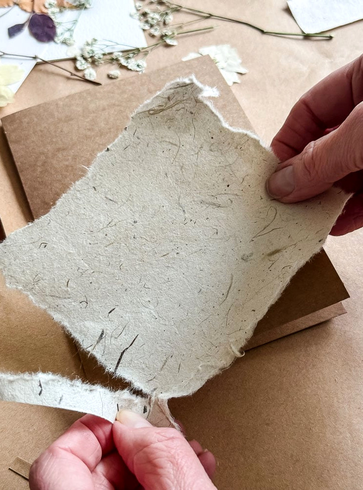 ripping a piece of paper to use on a handmade card