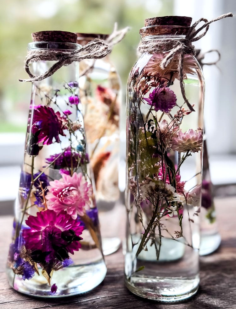 bottles filled with oil and dried flowers