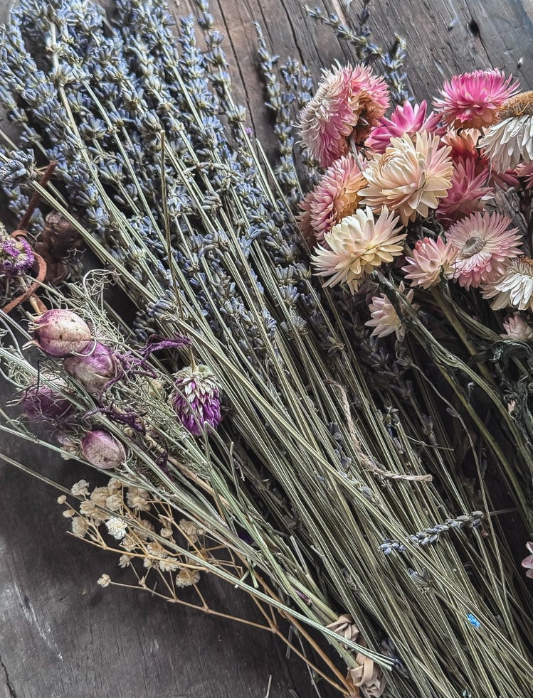 dried flowers including lavender and strawflowers bundled on a table