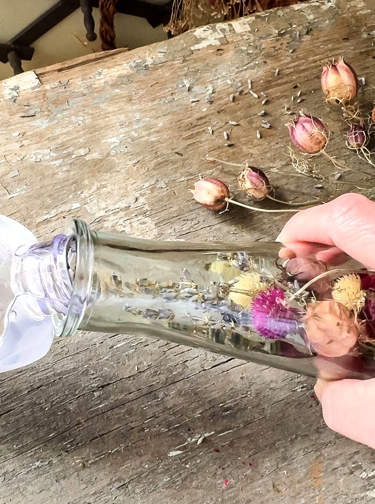 pouring mineral oil into a flower herbarium bottle